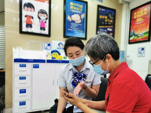 建行成都第六支行，大堂經(jīng)理為客戶介紹手機(jī)銀行“大字”模式